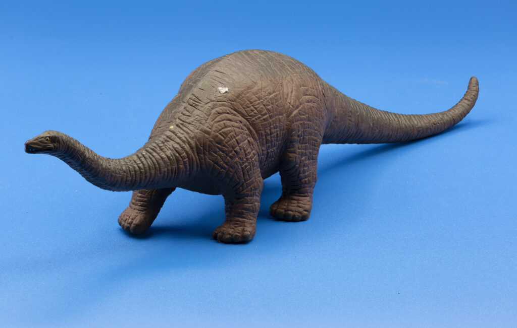 closeup of a small model brachiosaurus on a blue 2023 11 27 05 27 01 utc - Universidade Marketplaces